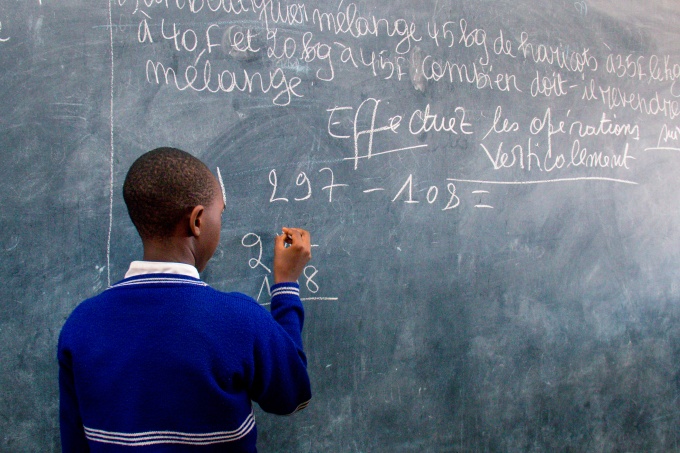 Student writing on the black board. Burundi.