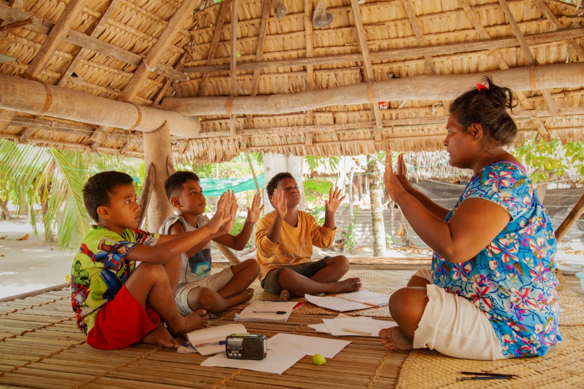 Des enfants suivant des cours via la radio avec leur enseignante à Kiribati. Crédit : UNICEF/UN0771689/Rice Chudeau